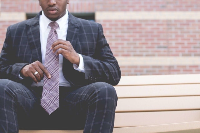 man sitting in plaid suit and tie
