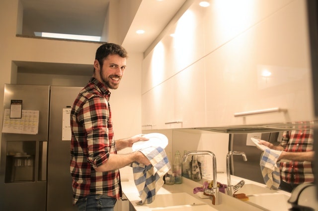 Man in plaid shirt washing dishes
