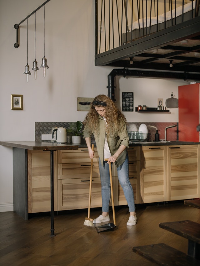 Woman sweeping a kitchen floor