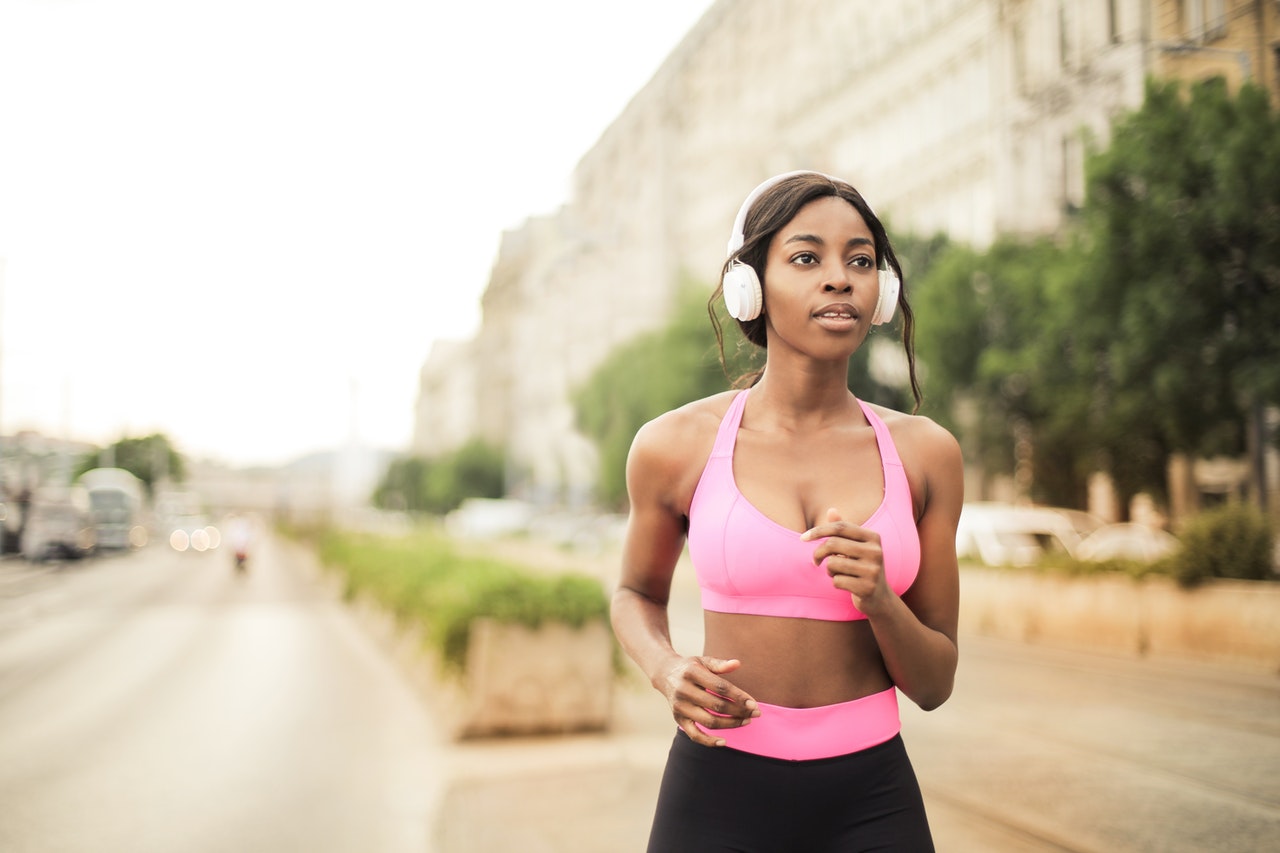 Fitness model jogging in pink sports bra and black leggings